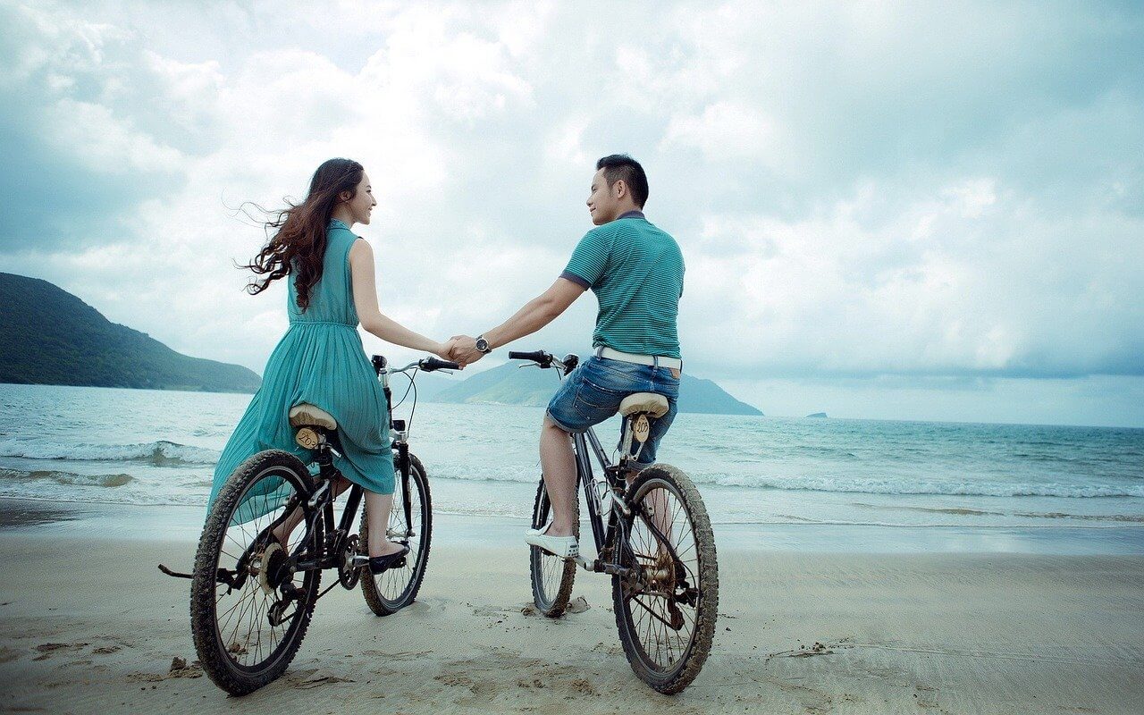 couple promenade a velo main vacances en resort au maroc