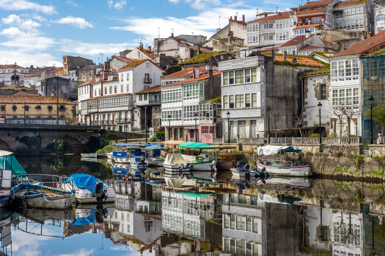 Bateaux de pêche dans la rivière Mandeo avec les bâtiments typiques du beau village de Betanzos