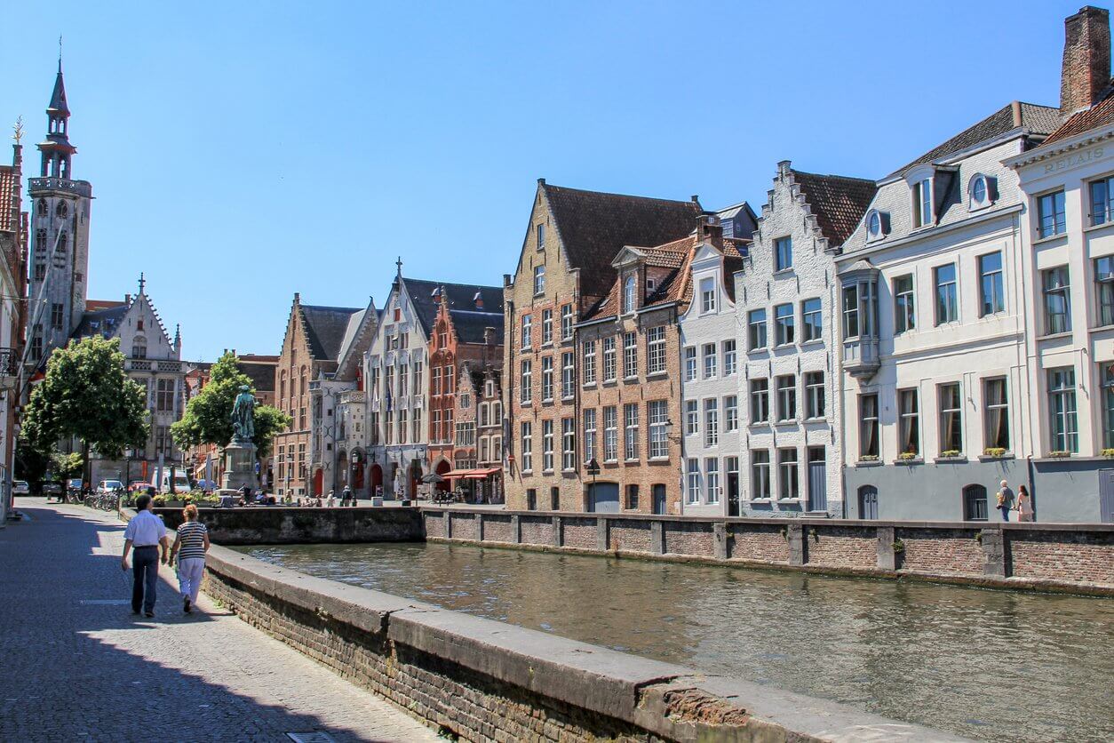 couple marchant vers la place jan van eyck et le poortersloge bruges belgique