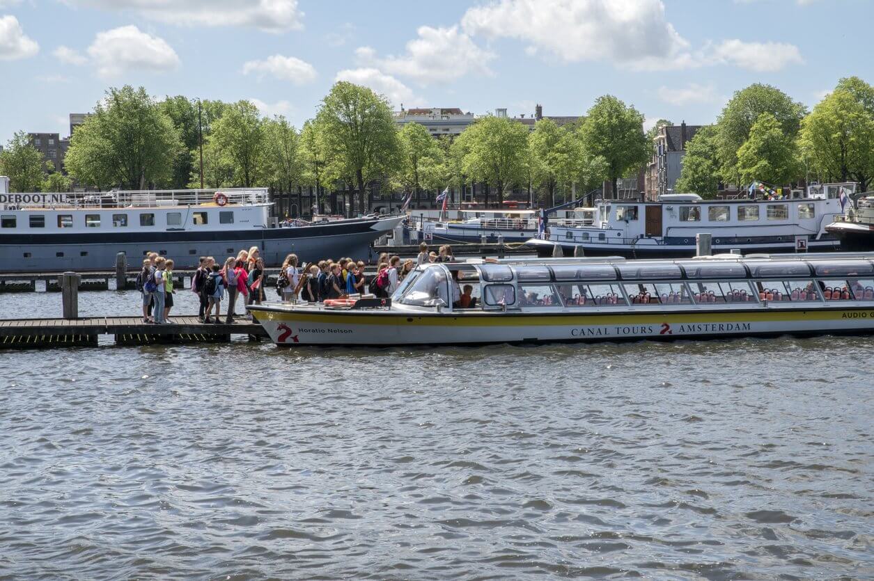 des enfants montent sur un bateau de croisiere sur le canal a amsterdam aux pays bas