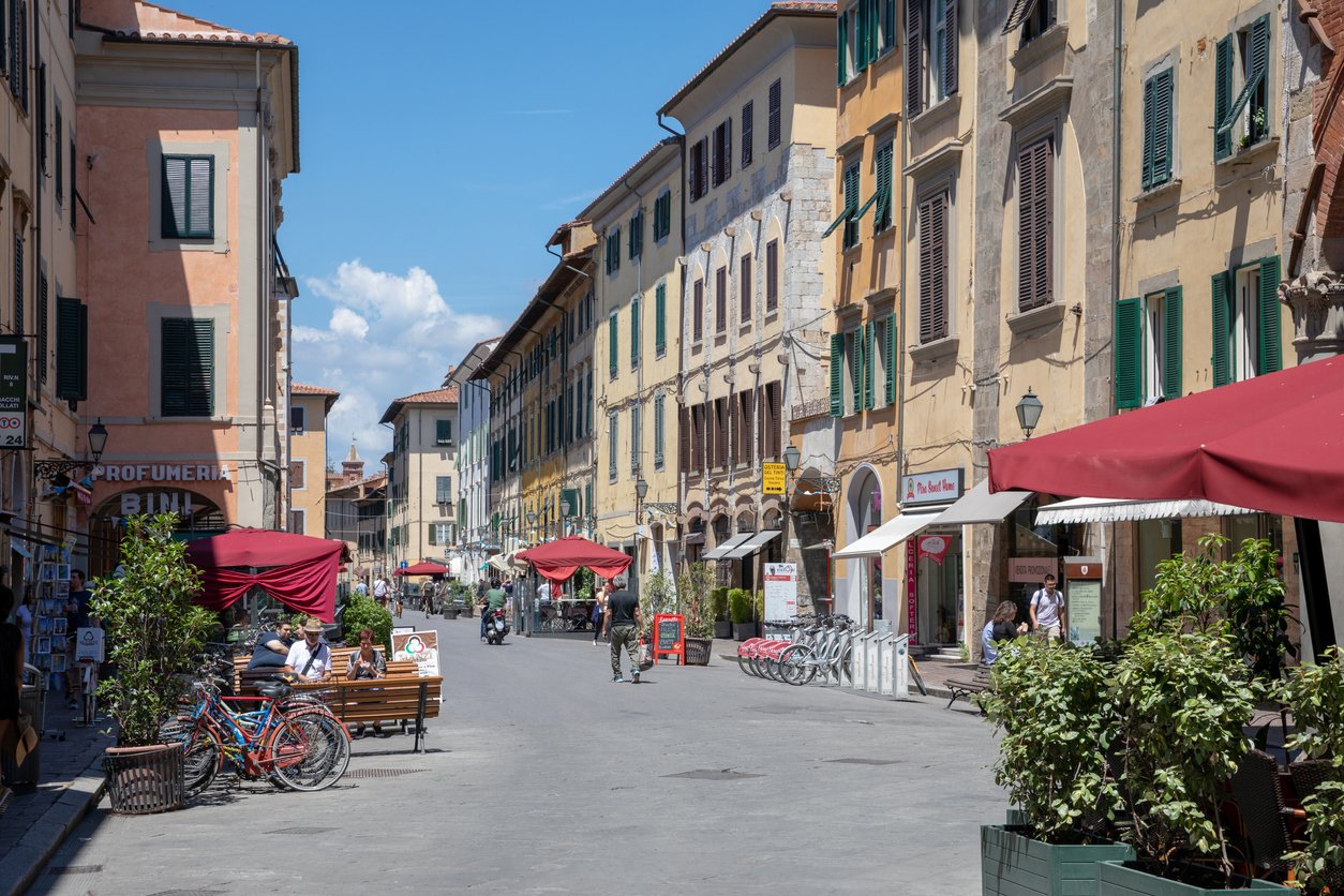 Walking on Borgo Stretto street in Pisa city with historic buildings