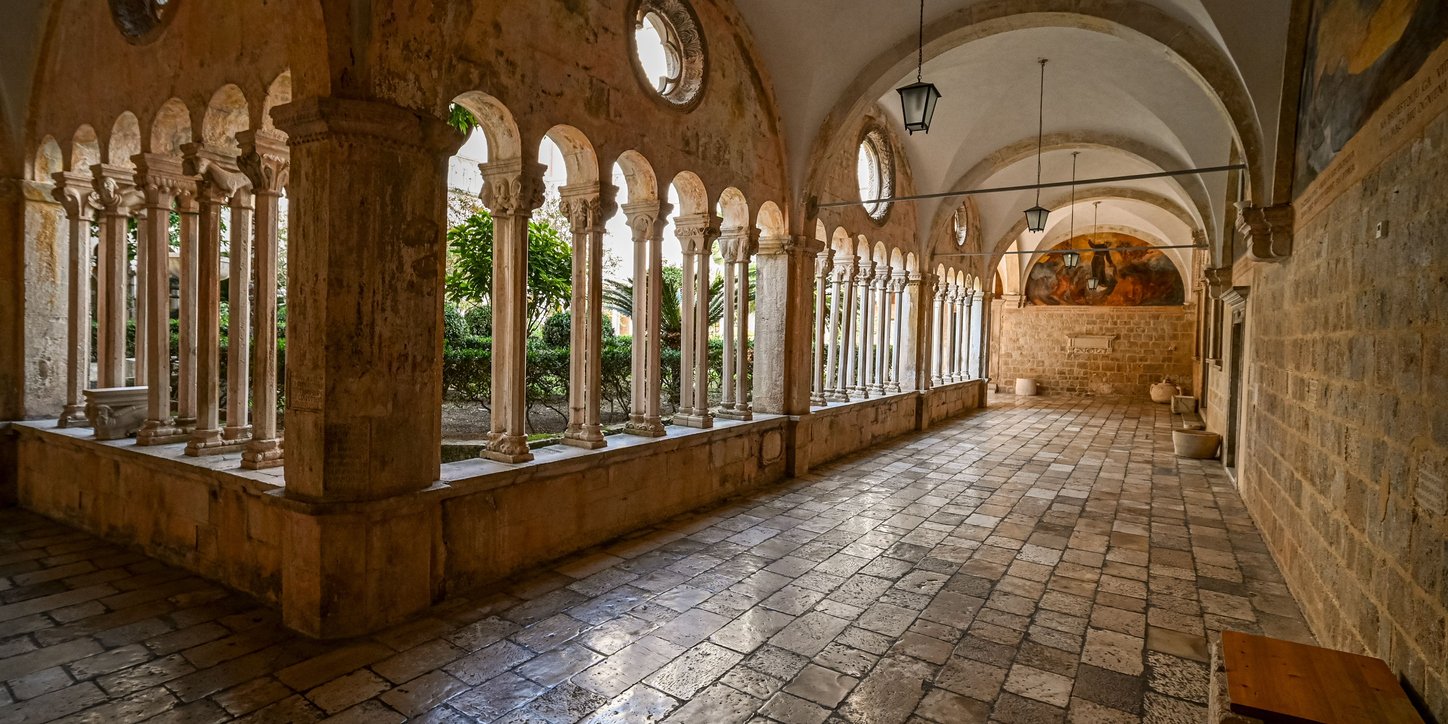 Tiled floor and arch stone wall inside Franciscan Church and Monastery in Dubrovnik, Croatia