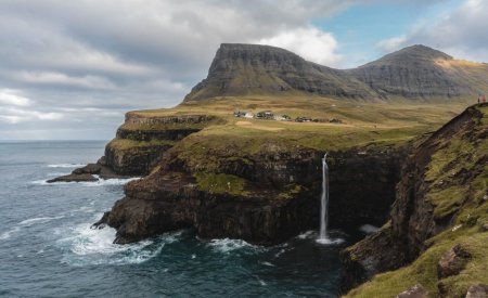 brown and green mountain beside body of water during daytime