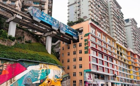 a group of people walking down a street next to tall buildings